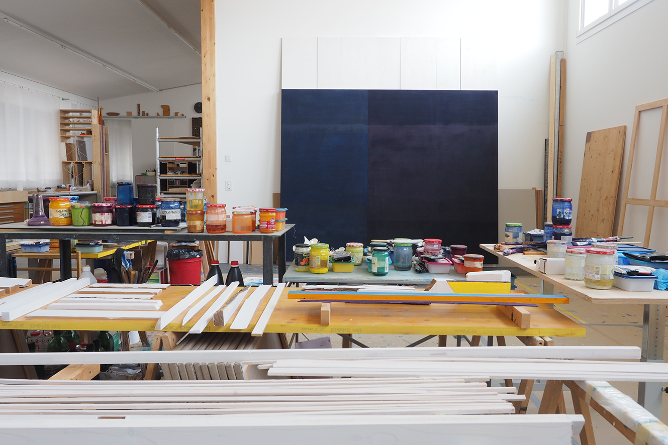 Atelier von Roger Schnyder in Doppleschwand. Weisse Hölzer, tiefdunkelblaue Malerei an weisser Zwischenwand stehend.